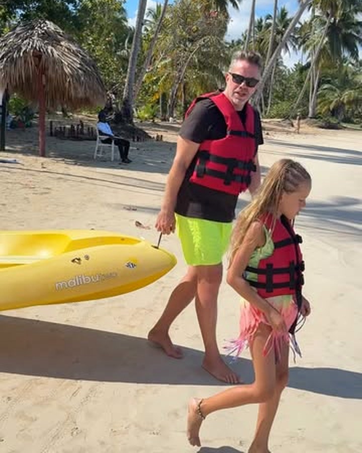 Federico con sus hijos llevando un kayak en la playa del hotel